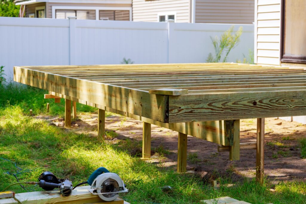 Deck construction work in garden with some torx circular saw, overlooking backyard landscape